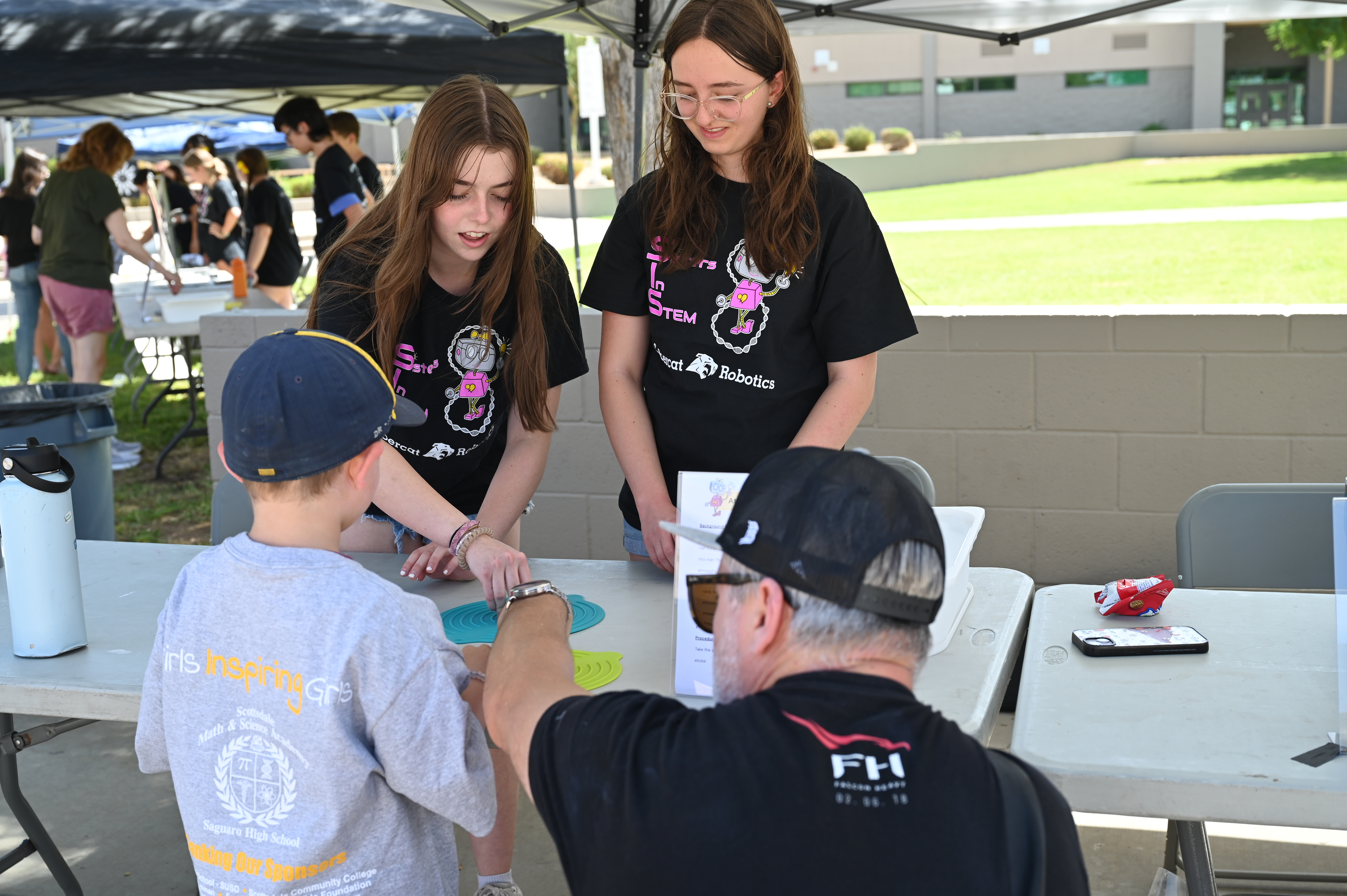 SiS volunteers running a hands-on activity booth outdoors